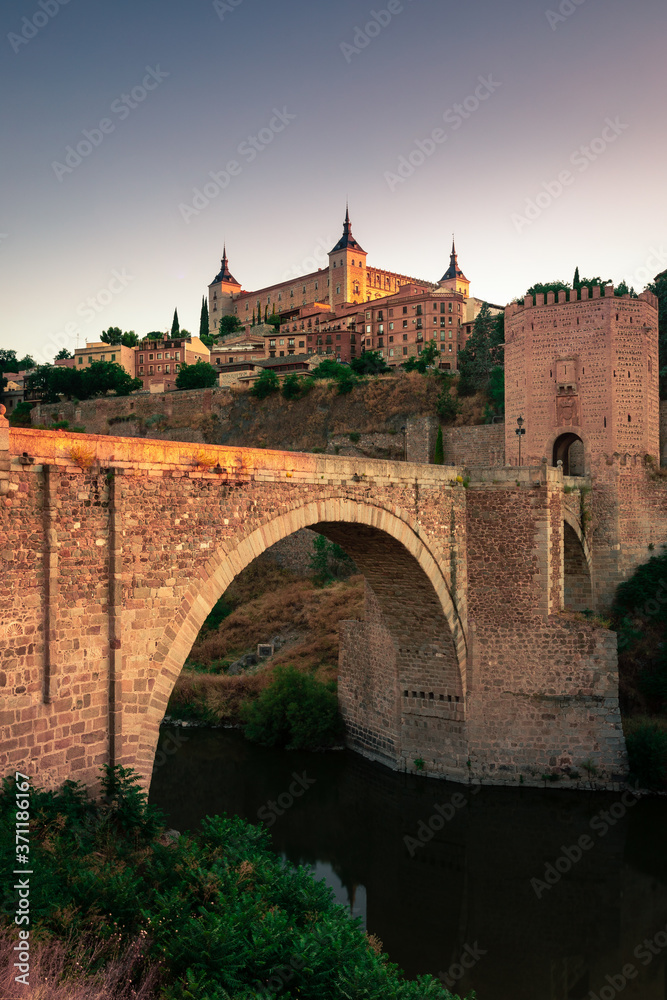 View of Alcantara Bridge and the Alzacar from Toledo, capital of La Mancha, Spain.