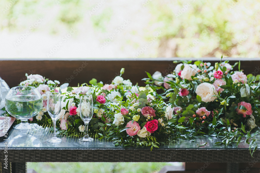 Wedding flowers, roses, chrysanthemums, decorations, bouquets, glasses on the table close-up. Festive accessories and details. Wedding flowers, roses, chrysanthemums, decorations, bouquets, glasses on the table close-up. Festive accessories and details.