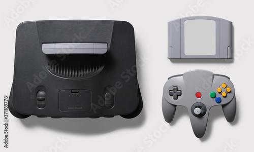 Black N64 gaming consoler with grey controller joypad and game on a white background