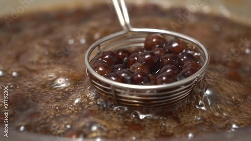 Cooking, boiling brown sugar flavor tapioca pearl balls, ingredient of bubble tea, preparing food and drink, close up, recipe cookbook steps design concept, slow motion.