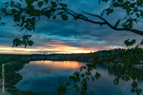 Sunset over a large lake in nature in summer. © amarinchenko106