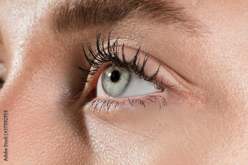 Hopeful. Close up of face of beautiful caucasian young woman, focus on eyes. Human emotions, facial expression, cosmetology, body and skin care concept. Well kept cheeks, narutal make up. Wellbeing. photo