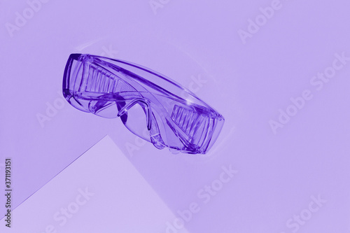 Transparent tinted glasses on lilac background. Creative monochrome layout.