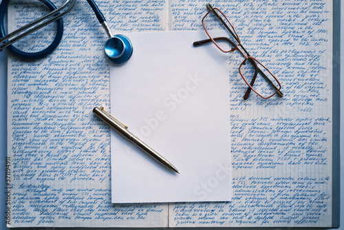 Hand-written medical text Stethoscope, ballpen and spectacles over hand-written medical notes. Medical writing or publishing.