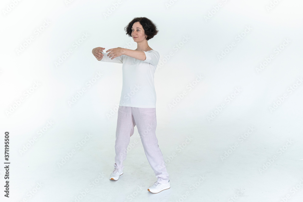 woman practicing qi qong at white studio traditional chinese gymnastics woman practicing qi qong at white studio traditional chinese gymnastics