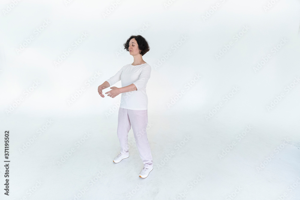 woman practicing qi qong at white studio traditional chinese gymnastics woman practicing qi qong at white studio traditional chinese gymnastics