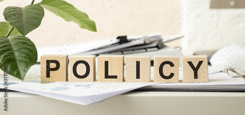 the word policy is written on cubes close-up. light background in the background of the coin. High quality photo