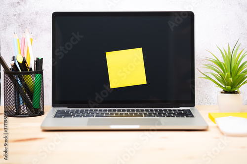 Yellow post-it on the laptop. memo paper on a screen laptop computer. scheduled for job or short note for work concept.