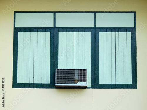 traditional green wood window on yellow wall of home