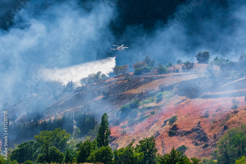 Helicopter discharging water into a mountain fire