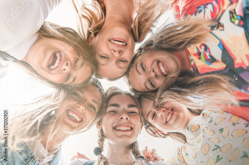 Teenage school friends smiling to camera. Diverse group of sporty attractive girls enjoy time together, smiling people in sportswear, happy friends looking at camera. Well being, wellness concept