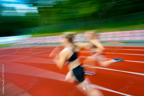 Running woman on sport track, blurred motion abstract background. Sport concept