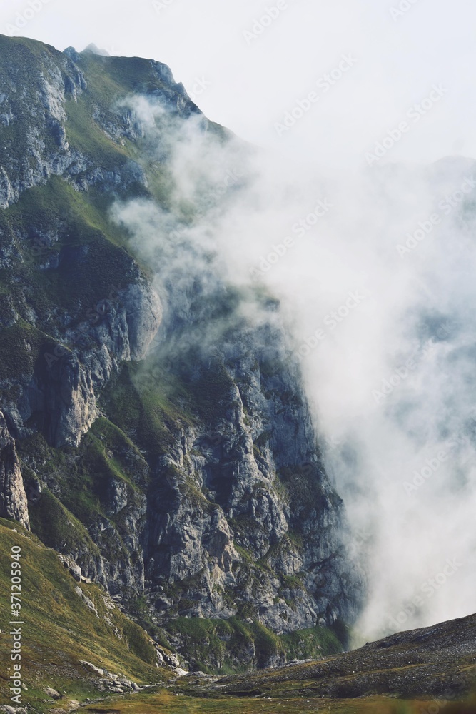 fluffy white clouds among the mountain ridges. mist at high altitude