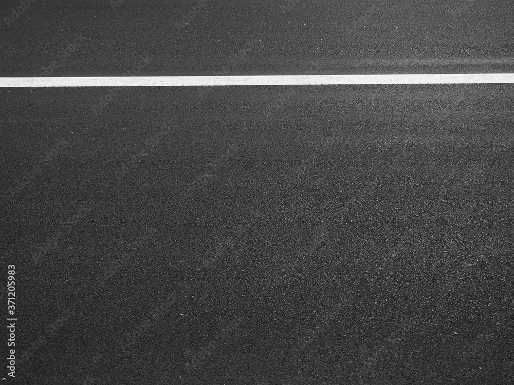 dark asphalt road with white line of lane