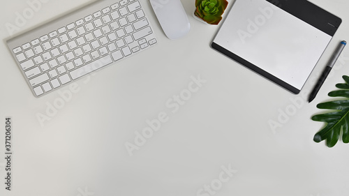 Stylish office table desk. Workspace with pen tablet, mouse and keyboard on white background, Top view. photo