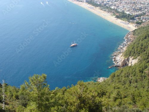 View beach of the Alanya coast from mountain. Boats floats in mediterian sea.