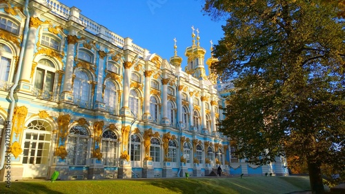 Facade and golden domes of Catherine Palace located in a suburb of St. Petersburg, in Pushkin city (Tsarskoe selo), Russia. Travelling. Russian royal tourist attractions. Sun rays and shadows on wall.
