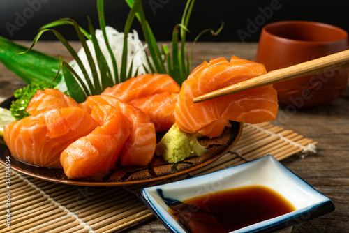 Sashimi, Salmon, Japanese food chopsticks and wasabi on the wood table