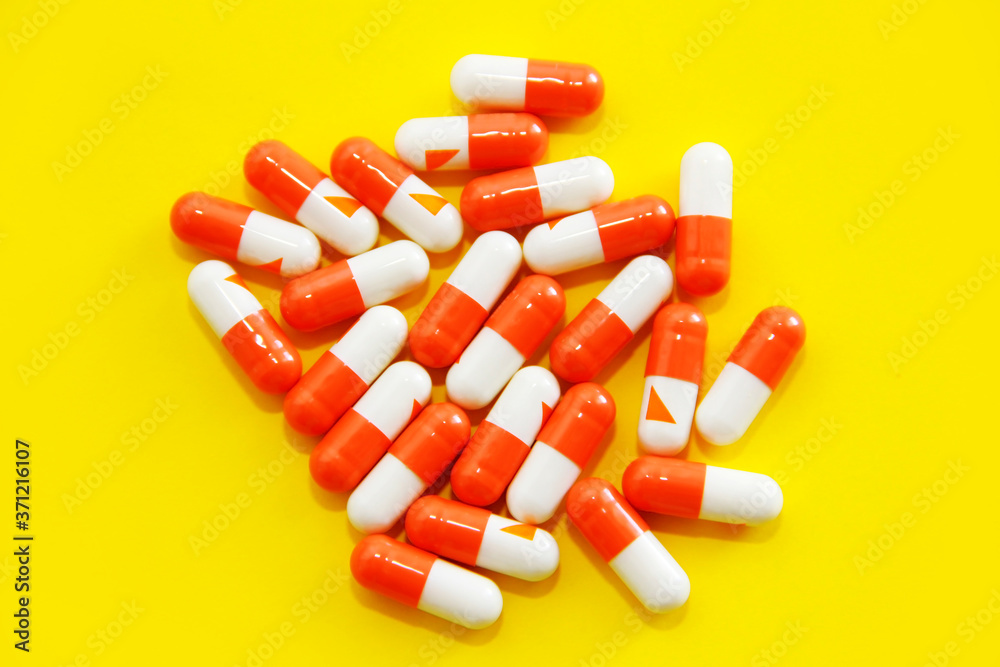 medical capsules with medication on a yellow background