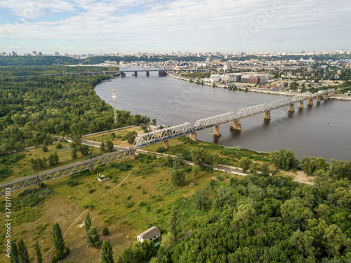 Aerial drone view, The train travels along the railway bridge across the river.