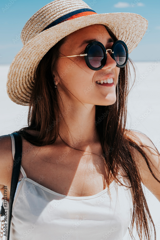 Summer portrait of a beautiful woman in a straw hat and sunglasses close-up.