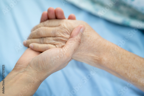 Fototapeta Naklejka Na Ścianę i Meble -  Doctor holding touching hands Asian senior or elderly old lady woman patient with love, care, helping, encourage and empathy at nursing hospital ward, healthy strong medical concept