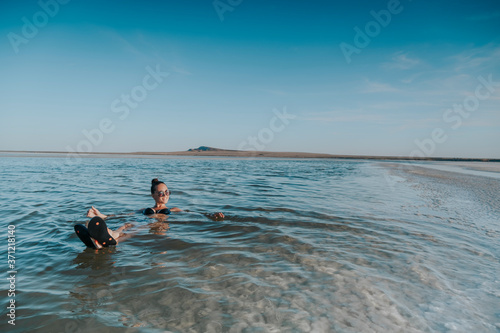 The woman swims in the dead sea. Lie on the water.