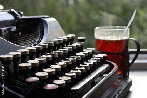 an old typewriter and a glass of hot tea