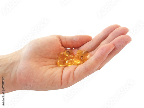 Omega 3 fish oil capsules on the palm isolated on white background