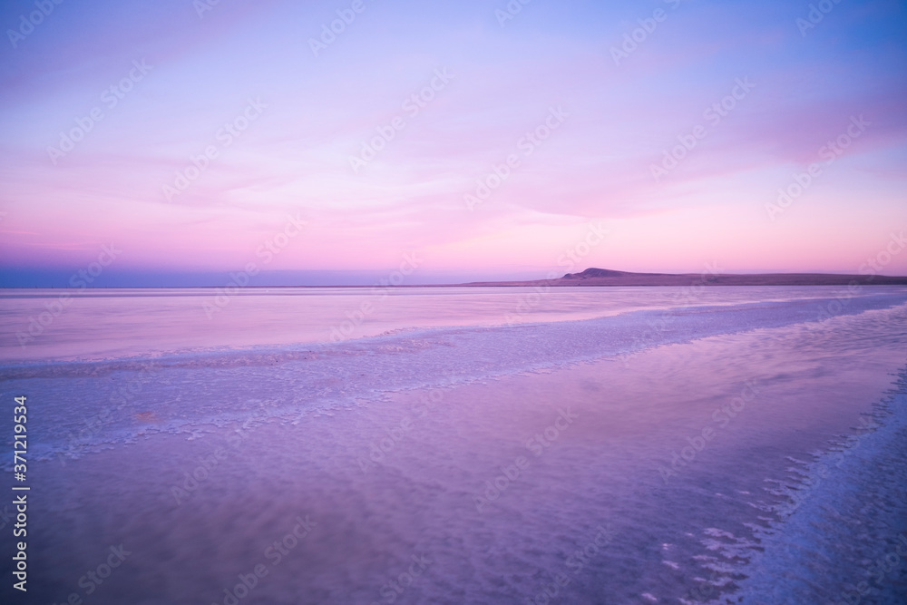 Beautiful pink sunset on a salt lake. Purple sky at sunset.