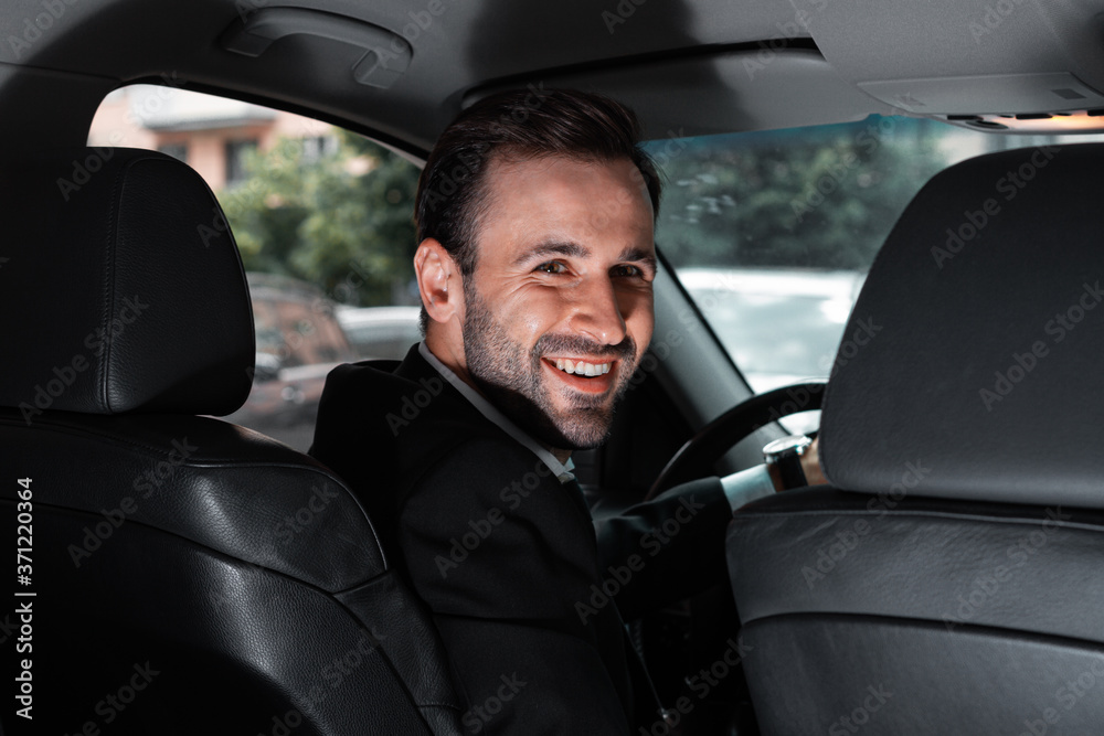 Succesful and happy businessman in car smiling