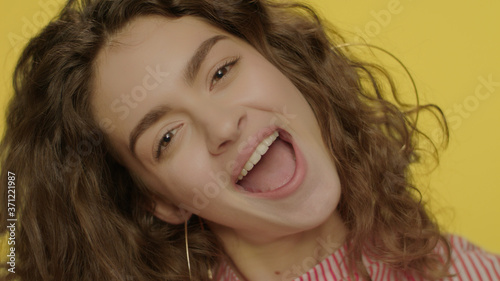 Happy woman having fun with lemon halves in studio. Fashion model face smiling