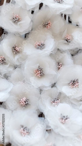 Artificial handmade flowers made out of beautiful organza and tulle fabric texture in broken white color