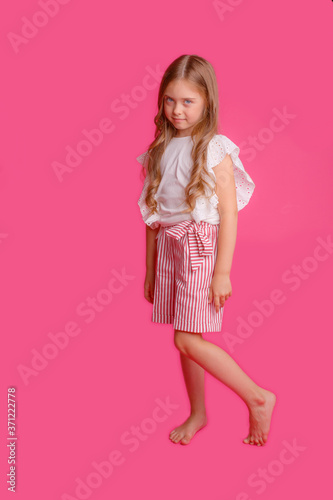 cute girl with long hair posing on a pink background in the Studio © Olesya Pogosskaya