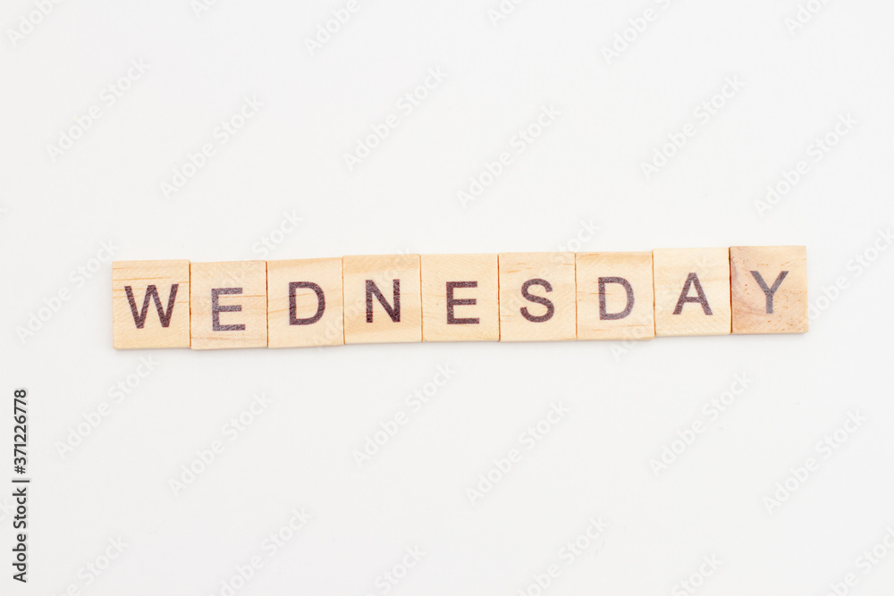 Word WEDNESDAY made from wooden cubes on white. Days of the week