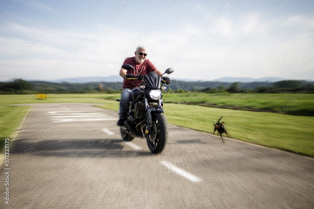 A middle-aged man enjoys with his motorcycle