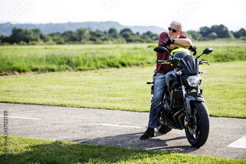 A middle-aged man enjoys with his motorcycle