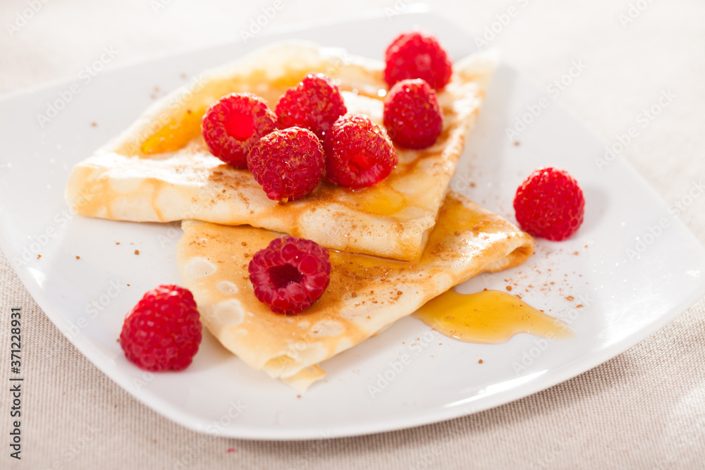 delicious  pancakes with fresh raspberries and honey