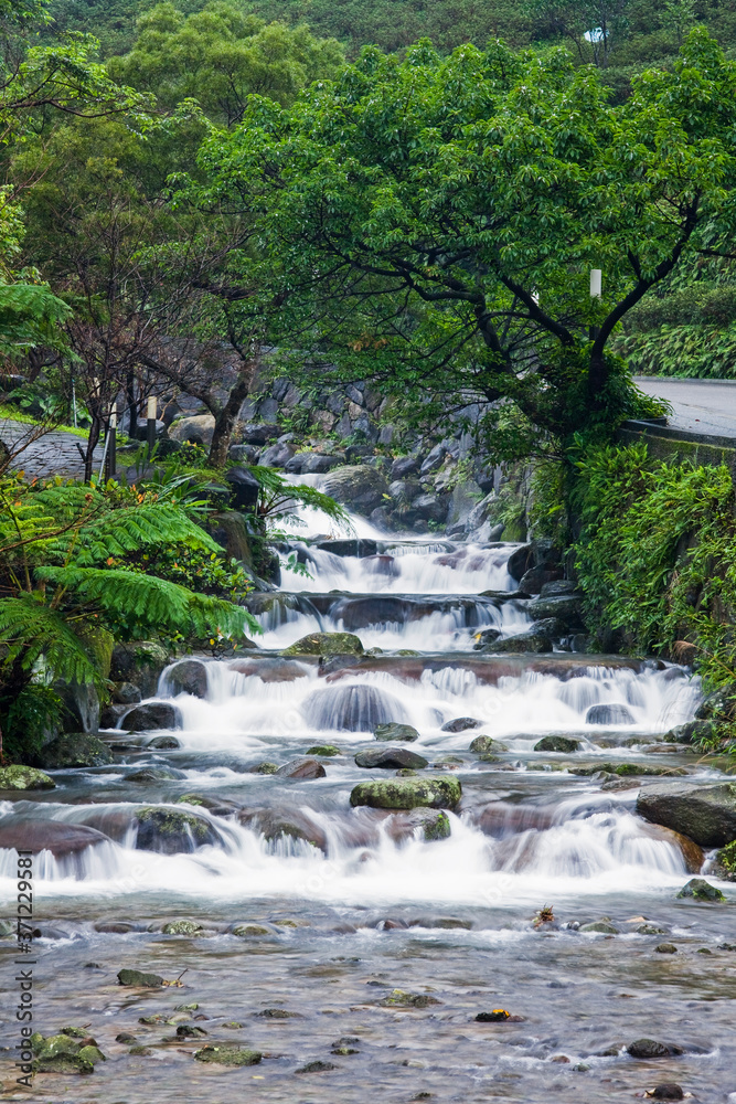 Creek or stream water flowing past rocks and stones Creek or stream water flowing past rocks and stones