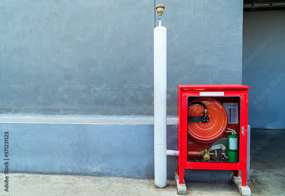 Fire extinguishers prepare in the event of fire, fire protection equipment in a red box beside the cement wall for the background, fire extinguishers on the outside walls