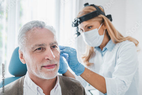 Senior male patient visiting doctor otolaryngologist photo