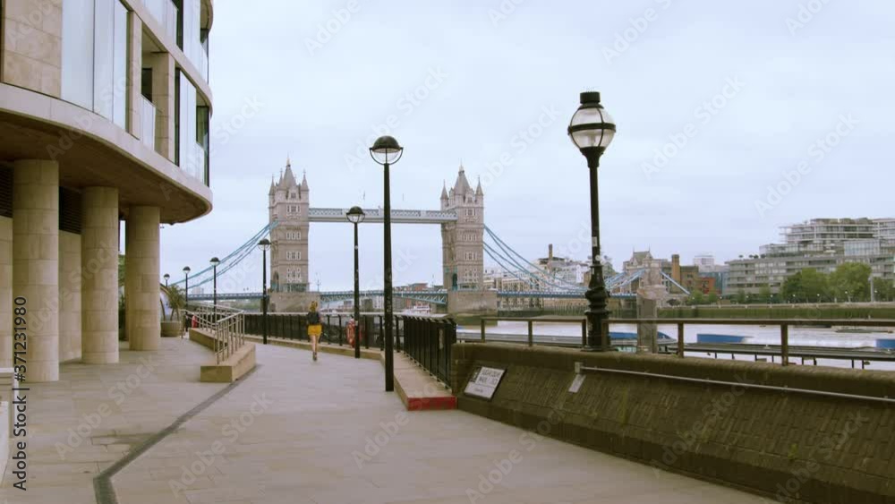 Woman running away from camera exercising by tower bridge central London Woman running away from camera exercising by tower bridge central London