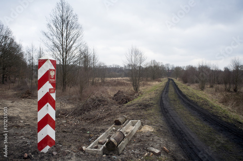 oczyszczony pas drogi granicznej z widoczym polskim słupem granicznym