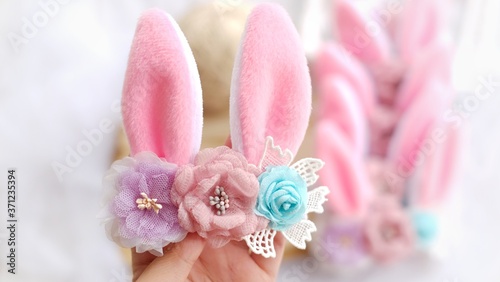 Handmade flowers as headband hair accessory with bunny or rabbit ears as decoration in soft pastel colors