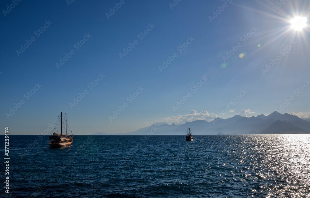 Excursion tourist boat against mountain range in the Mediterranean Sea, Antalya, Turkey
