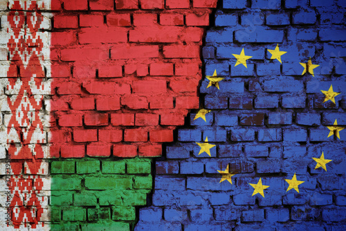 Brick wall with a flag of Belarus and European Union with a big crack in the middle. Concept of sanctions and political problems © Vitalii
