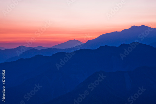 Layers of magnificent mountains with colorful clouds background at sunrise view