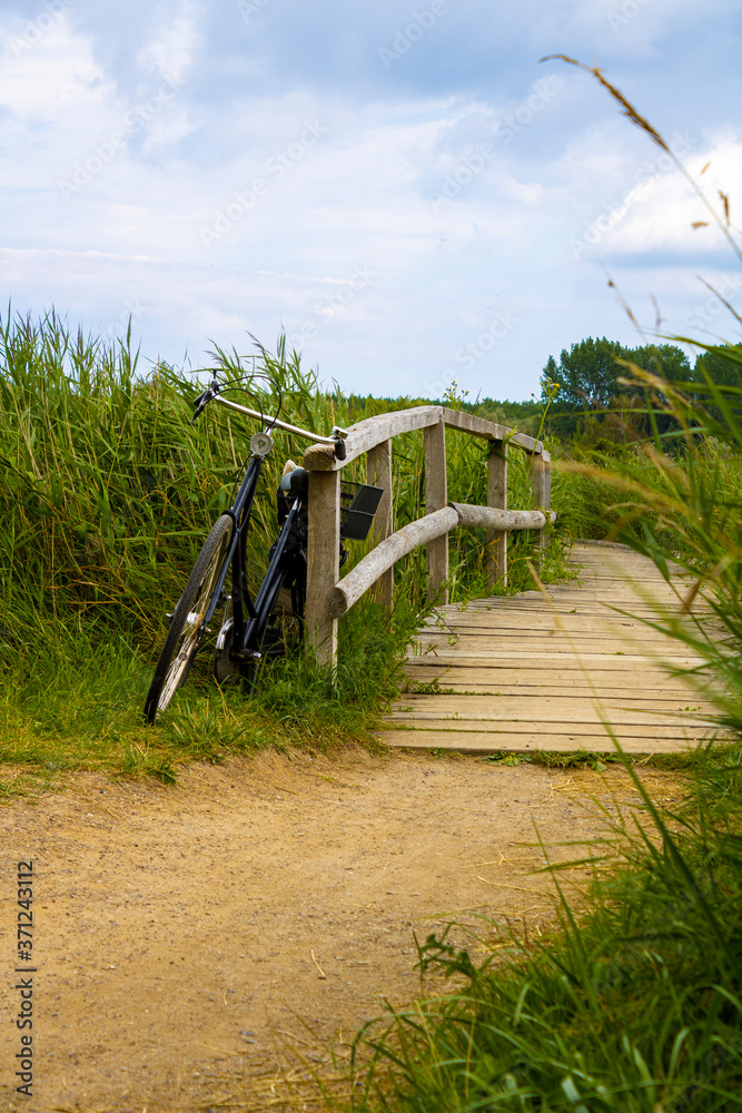 Old bike standing at a wooden boardwalk at the coast Old bike standing at a wooden boardwalk at the coast