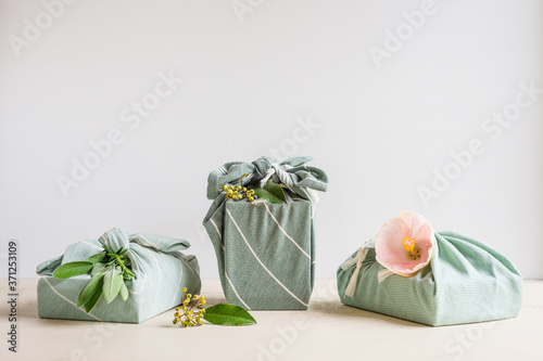 three gifts wrapped in cotton material photo