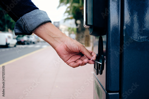 young man paying in a parking meter